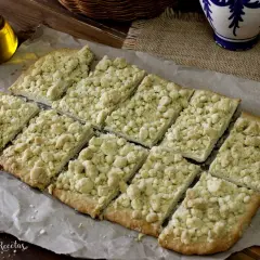 Deliciosa coca de mollitas, cortada en porciones y lista para disfrutar. Un postre casero con una textura crujiente y dulce.
