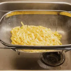 Espaguetis recién escurridos en un colador, listos para ser parte de deliciosas recetas de espaguetis.