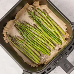 Espárragos frescos listos para cocinar en la freidora de aire. Se ven deliciosos y saludables.