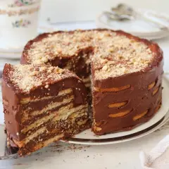 Deliciosa marquesa de chocolate, con capas de galletas y crema de cacao, espolvoreada con frutos secos.