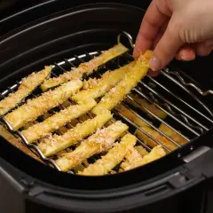 Palitos de calabacín empanados listos para cocinar en la freidora de aire.