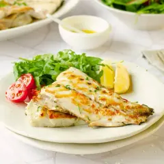 Deliciosa corvina a la plancha, servida con rúcula fresca, tomates cherry y gajos de limón. Un plato ligero y sabroso.