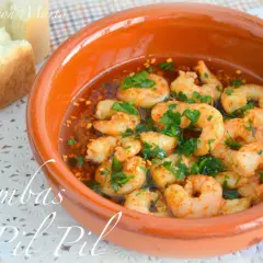 Gambas al pil pil burbujeantes en cazuela de barro, con pan rústico al lado. ¡Un clásico irresistible!