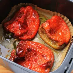 Pimientos rojos asados en freidora de aire, con la piel arrugada y jugosos.