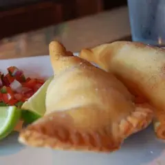 Dos empanadillas doradas con pico de gallo y limón. ¡Perfectos rellenos para empanadillas!