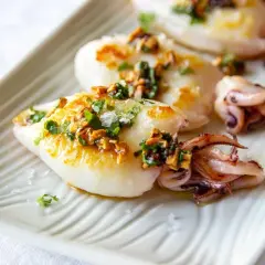 Deliciosos chipirones a la plancha, dorados y jugosos, con un toque de ajo y perejil picado.