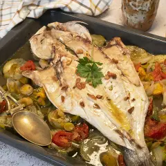 Lubina al horno con verduras asadas, ajo crujiente y perejil fresco. Un plato delicioso y saludable.