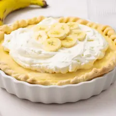 Delicioso pastel de plátano con crema batida y rodajas de plátano fresco. Un postre perfecto para cualquier ocasión.