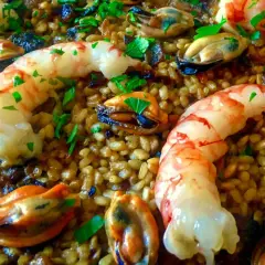 Arroz con gambas y mejillones, un plato lleno de sabor y color, con el arroz dorado y los mariscos frescos.
