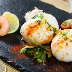 Deliciosa sepia en freidora de aire, servida con gambas, lima y tomates cherry.