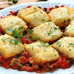 Bacalao con sanfaina: trozos de pescado blanco rebozado sobre una cama de pimientos rojos, berenjena y tomate.