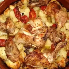 Rustidera de pollo dorada con patatas y pimientos asados, lista para servir.