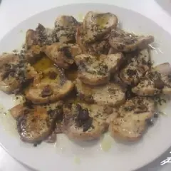 Delicioso emperador a la plancha, cortado en rodajas y servido con aceite de oliva y hierbas.