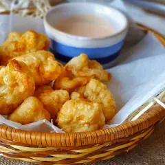 Fritos de rape crujientes y jugosos en una cesta con salsa.