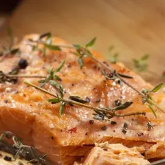 Delicioso salmón al horno, jugoso y dorado, con hierbas frescas y pimienta negra.