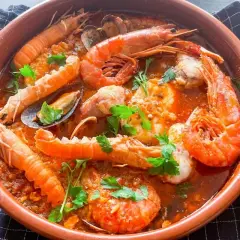 Zarzuela de pescado en cazuela de barro, con gambas, cigalas, mejillones y un rico sofrito.