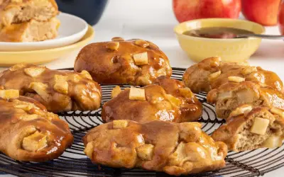 Buñuelos de manzana glaseados, con trozos de manzana visibles, sobre una rejilla.