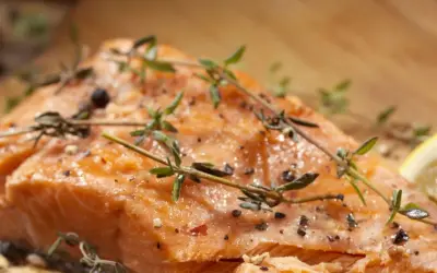 Delicioso salmón al horno, jugoso y dorado, con hierbas frescas y pimienta negra.