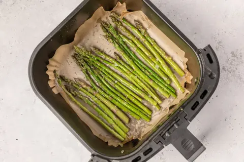 Espárragos frescos listos para cocinar en la freidora de aire. Se ven deliciosos y saludables.