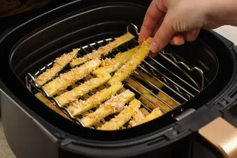 Palitos de calabacín empanados listos para cocinar en la freidora de aire.