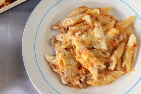 Un plato de macarrones del cardenal, cubiertos de salsa y queso, listos para disfrutar.