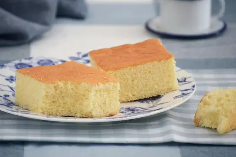 Dos porciones de pa de pessic esponjoso y dorado en un plato con diseño azul.