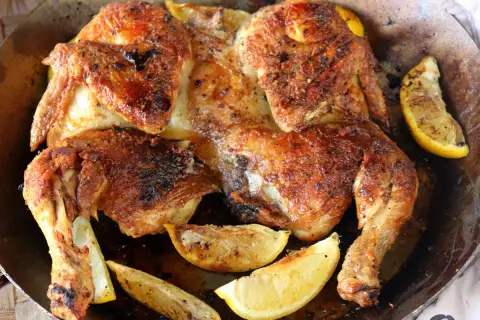Pollo asado dorado y jugoso, perfecto para desmenuzar y usar en deliciosas recetas. Acompañado de gajos de limón asado.
