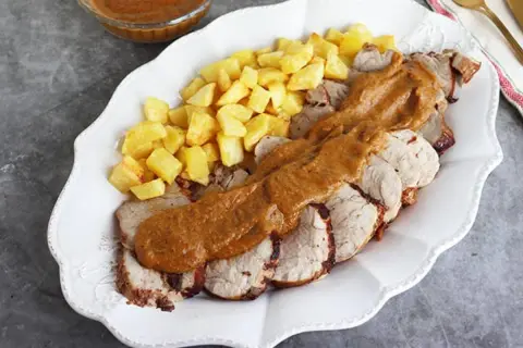 Solomillo a la cerveza jugoso y tierno, servido con patatas fritas crujientes y una rica salsa. ¡Un plato delicioso!