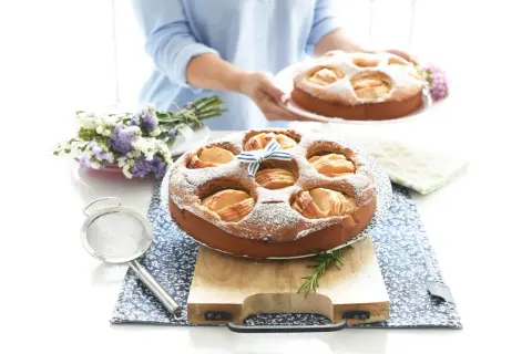 Deliciosa tarta de manzana Thermomix, espolvoreada con azúcar glas y decorada con un lazo azul.