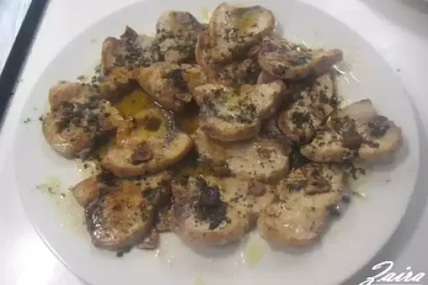 Delicioso emperador a la plancha, cortado en rodajas y servido con aceite de oliva y hierbas.