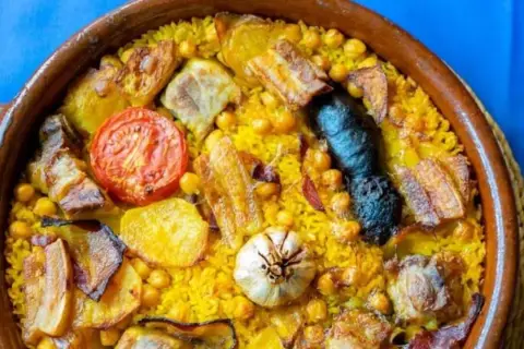 Arroz al horno en cazuela de barro, con garbanzos, patatas, tomate, ajo, morcilla y trozos de carne. ¡Un plato contundente y delicioso!