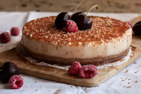 Tarta de queso con leche condensada, cubierta de frutos rojos y virutas de chocolate. ¡Un postre irresistible!