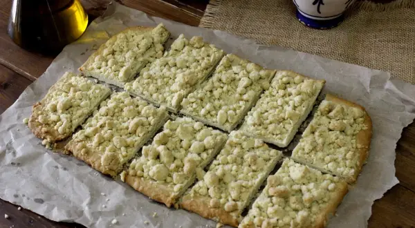 Deliciosa coca de mollitas, cortada en porciones y lista para disfrutar. Un postre casero con una textura crujiente y dulce.