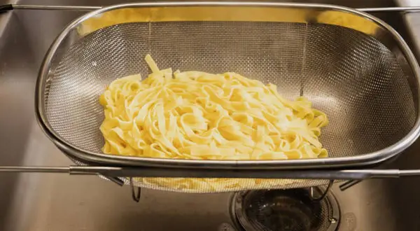 Espaguetis recién escurridos en un colador, listos para ser parte de deliciosas recetas de espaguetis.
