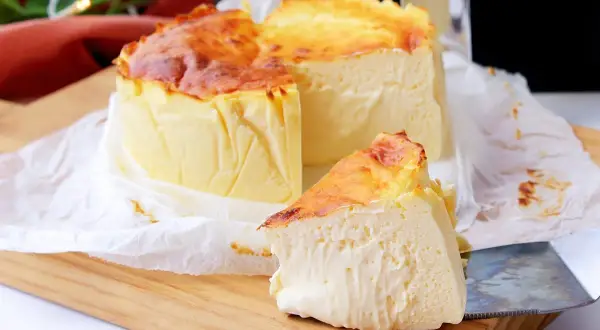 Tarta de queso en freidora de aire, dorada y cremosa, con una porción lista para disfrutar.