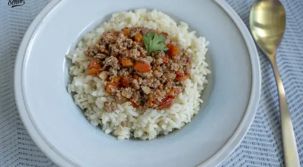 Un plato de arroz blanco cubierto con una sabrosa mezcla de arroz con carne picada, tomates y pimientos.