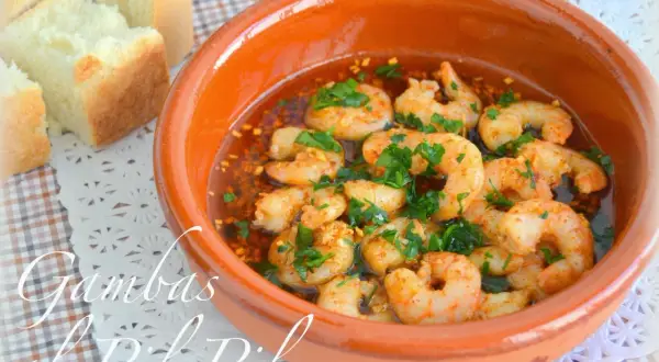 Gambas al pil pil burbujeantes en cazuela de barro, con pan rústico al lado. ¡Un clásico irresistible!