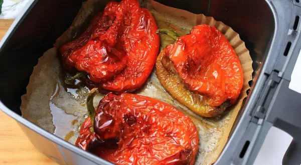 Pimientos rojos asados en freidora de aire, con la piel arrugada y jugosos.