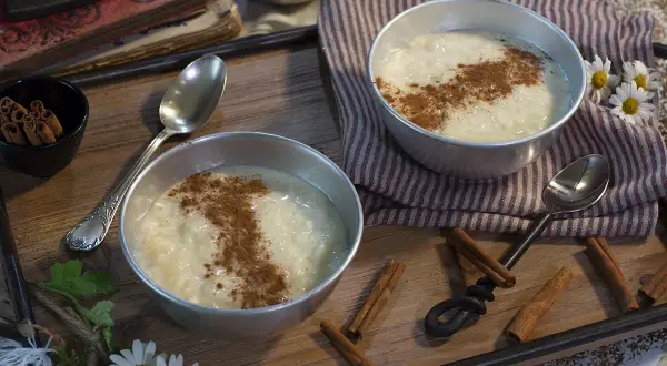 Dos cuencos de cremoso arroz con leche, espolvoreado con canela, listo para disfrutar. Un postre perfecto hecho con Thermomix.