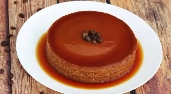 Delicioso flan de café, con su caramelo dorado y granos de café como decoración.