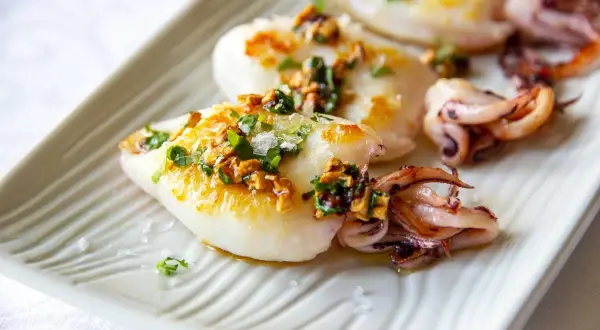 Deliciosos chipirones a la plancha, dorados y jugosos, con un toque de ajo y perejil picado.