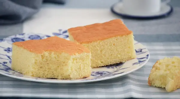 Dos porciones de pa de pessic esponjoso y dorado en un plato con diseño azul.