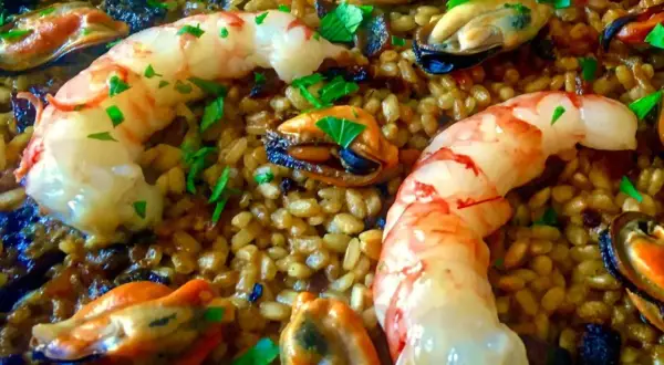 Arroz con gambas y mejillones, un plato lleno de sabor y color, con el arroz dorado y los mariscos frescos.