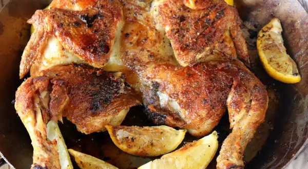 Pollo asado dorado y jugoso, perfecto para desmenuzar y usar en deliciosas recetas. Acompañado de gajos de limón asado.