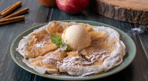 Deliciosas tortitas de arroz con manzana y canela, coronadas con helado de vainilla y espolvoreadas con azúcar glas.