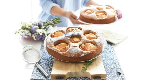 Deliciosa tarta de manzana Thermomix, espolvoreada con azúcar glas y decorada con un lazo azul.