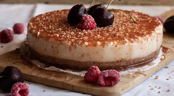 Tarta de queso con leche condensada, cubierta de frutos rojos y virutas de chocolate. ¡Un postre irresistible!