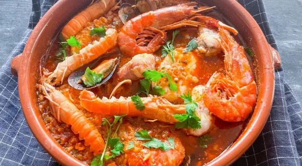 Zarzuela de pescado en cazuela de barro, con gambas, cigalas, mejillones y un rico sofrito.