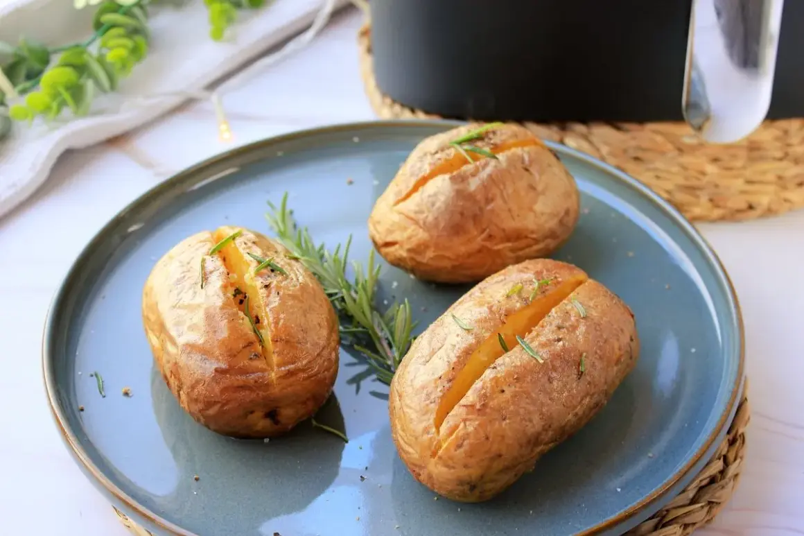 Tres patatas asadas airfryer doradas y crujientes, adornadas con romero fresco, listas para disfrutar.