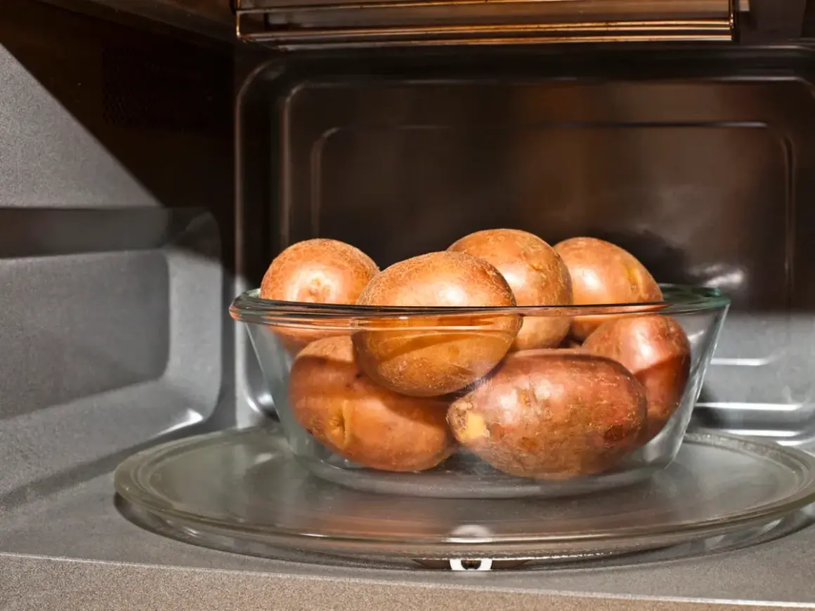 Patatas al microondas en un bol de cristal, listas para una cocción rápida y fácil.